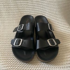 A pair of buckled straps in a versatile solid combined w/ a cork style sole Sz 9